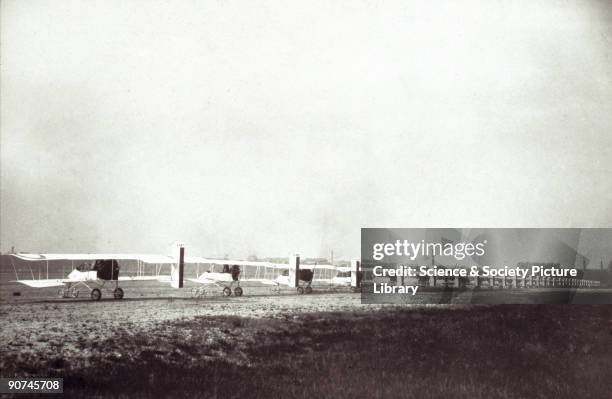 Photograph of a row of French Voisin biplanes parked on an airfield. Gabriel Voisin used the box-kite method of construction from 1905. He cooperated...