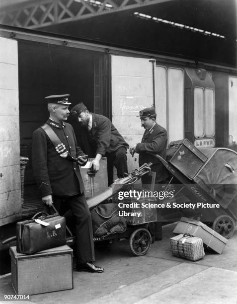Porters loading luggage into the baggage van of a London & North Western Railway train to Greenore, Euston Station, London, c 1907.