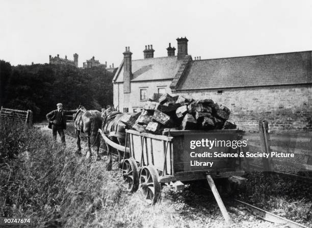 Peat is being transported in a horse-drawn railway cart. Belvoir Castle can be seen in the background.