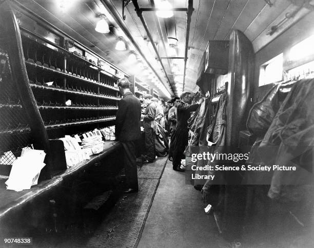 Postal workers sorting mail on a London, Midland & Scottish mail train.