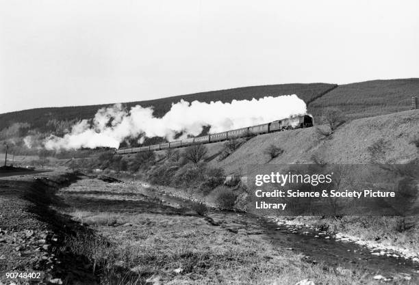 This locomotive No 46220 climbs the southern slope of Beattock Bank with the assistance of a banking engine, while the Elvan Water flows in the...