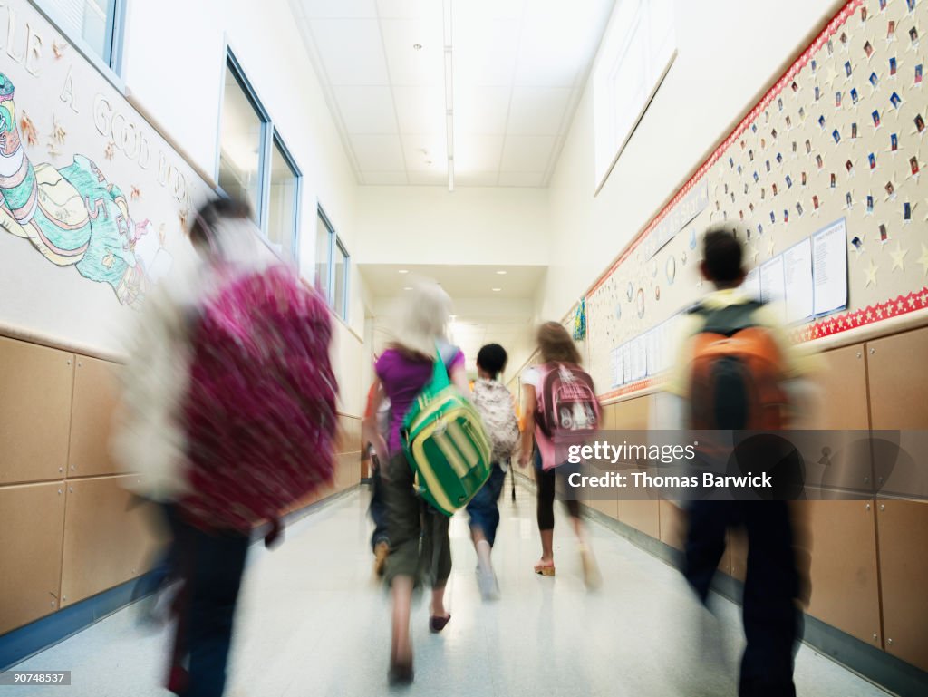 Young students walking down hallway of school
