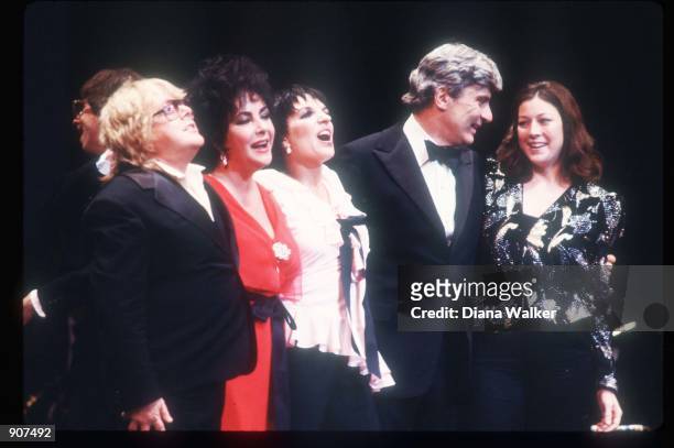 Paul Williams, his wife Katie, singer Liza Minnelli, actress Elizabeth Taylor and her husband Senator John Warner stand on stage at a party June,...