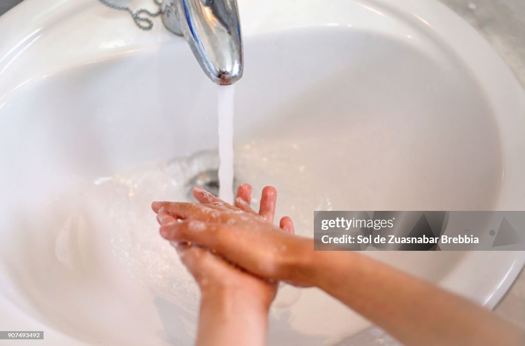 Close-up of the hands of a child washing his hands