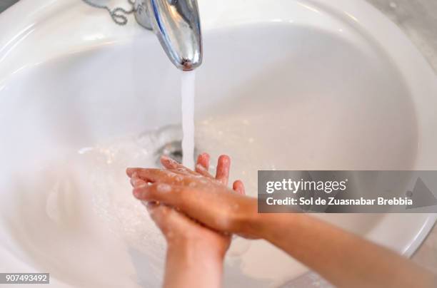 close-up of the hands of a child washing his hands - childrens closet stockfoto's en -beelden
