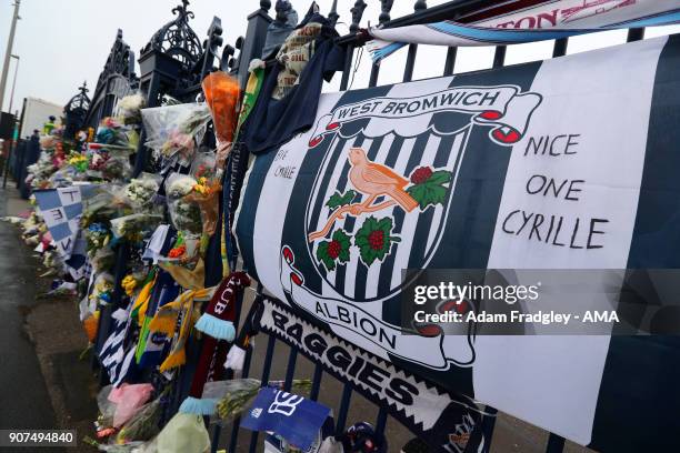 Floral tributes along with shirts and scarves left by West Bromwich Albion Fans in memory of Cyrille Regis on the Jeff Astle gates at The Hawthorns...