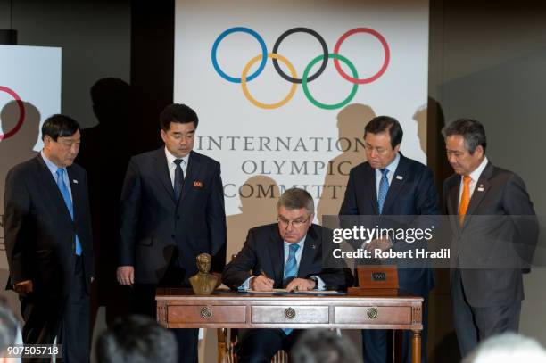 President Thomas Bach signs the declaration while having both delegates on side. On the left Mr. Il Guk Kim, Sport Minister and President of the...