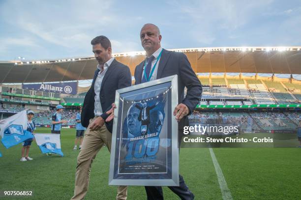 Graham Arnold coach of Sydney FC is presented with an award to mark his 100th match as coach by Sydney FC Chairman Scott Barlow during the round 17...