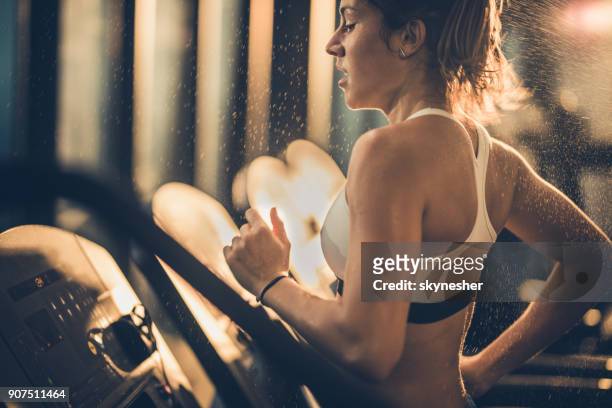 sweaty woman running on treadmill during sports training in a gym. - women working out gym stock pictures, royalty-free photos & images