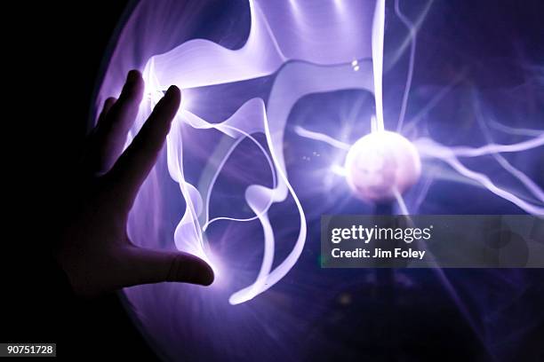 closeup of a hand touching a plasma lamp. - ondas electromagneticas fotografías e imágenes de stock