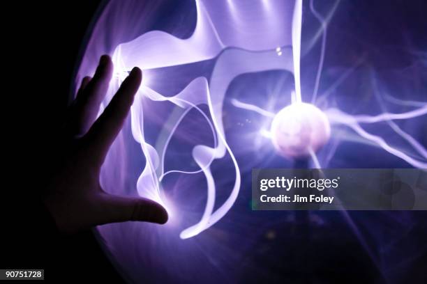 closeup of a hand touching a plasma lamp. - electromagnetic stock pictures, royalty-free photos & images