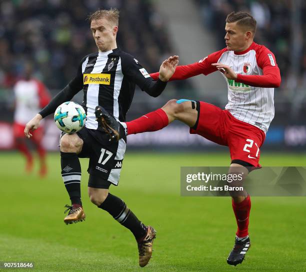 Oscar Wendt of Moenchengladbach fights for the ball with Alfred Finnbogason of Augsburg during the Bundesliga match between Borussia Moenchengladbach...