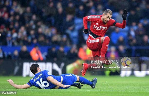 Roberto Pereyra of Watford is tackled by Aleksander Dragovic of Leicester City during the Premier League match between Leicester City and Watford at...