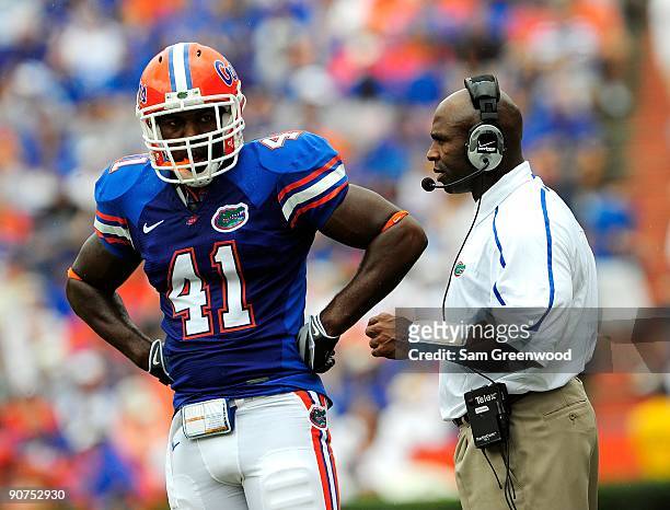 Defensive coordinator Charlie Strong of the Florida Gators talks with Ryan Stamper during the game against the Troy Trojans at Ben Hill Griffin...