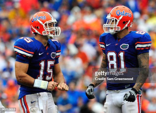 Tim Tebow of the Florida Gators speaks with Aaron Hernandez during the game against the Troy Trojans at Ben Hill Griffin Stadium on September 12,...