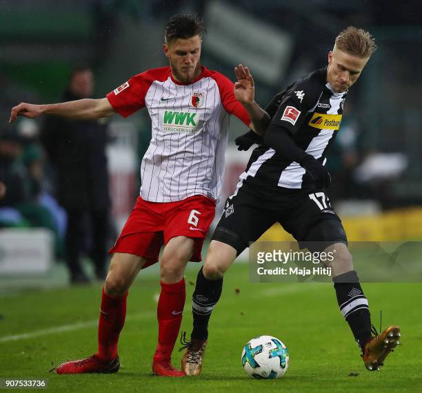 Jeffrey Gouweleeuw of Augsburg fights for the ball with Oscar Wendt of Moenchengladbach during the Bundesliga match between Borussia Moenchengladbach...