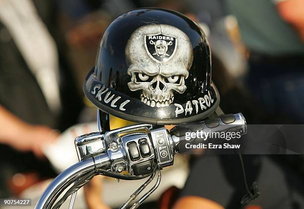 Mini biker helmet with a Oakland Raiders logo is seen on the handle bar of a motorcycle in the parking lot outside Oakland-Alameda County Coliseum...