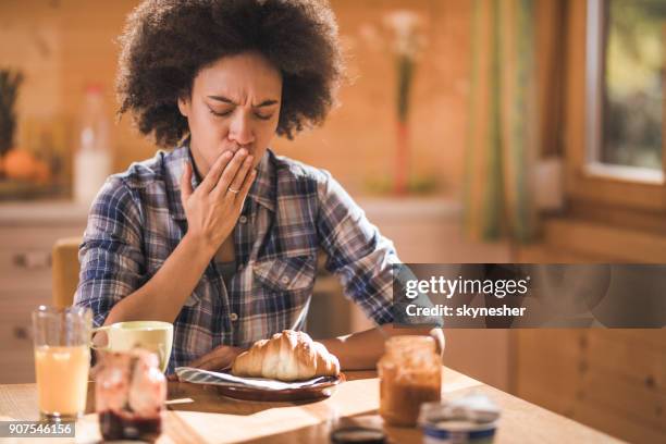 jonge african american vrouw gevoel misselijkheid tijdens ontbijt eetkamer. - morning sickness stockfoto's en -beelden