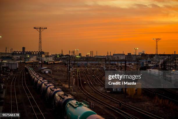 at the base of a freight train, at the sunset. - train yard at night stock pictures, royalty-free photos & images