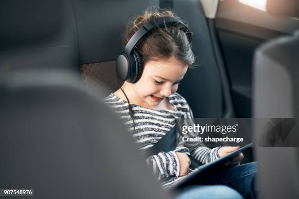 シートベルトし、オンラインの世界に接続しているすべて - girl in car with ipad ストックフォトと画像