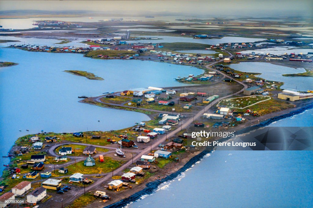 Aerial view of the Hamlet of Tuktoyaktuk on the shores of the Beaufort Sea in the Canadian Arctic. Visible : Black sand Bags along shore to prevent erosion of coast from Beaufort Sea (Arctic Ocean) - Tuktoyaktuk, Northwest Territories - Arctic Canada.
