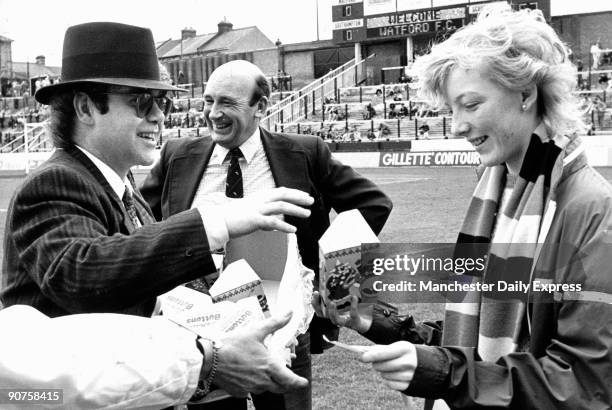 British rock star Elton John, chairman of Watford Football Club, chairman handing out Easter eggs to fans.