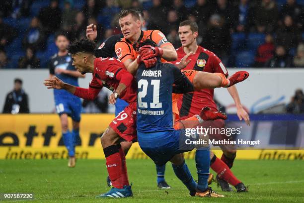 Benjamin Henrichs of Bayer Leverkusen , Benjamin Huebner of Hoffenheim and goalkeeper Bernd Leno of Bayer Leverkusen bump into each other during the...