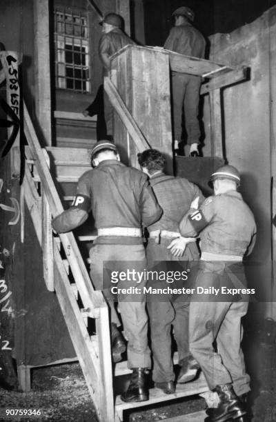 The first of three Germans to be hanged for the murder of a baled-out American airman. Kohn is led up the 13 steps to the gallows by military police.