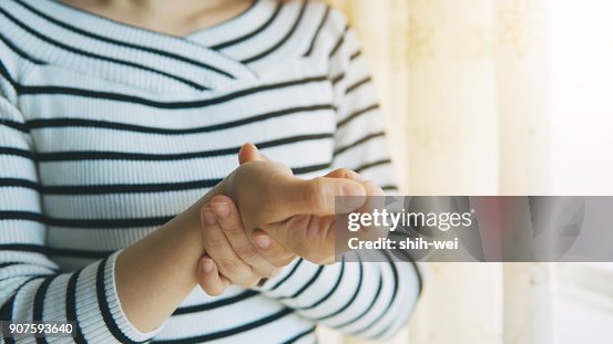 Woman massaging her arthritic hand and wrist Woman massaging her arthritic hand and wrist