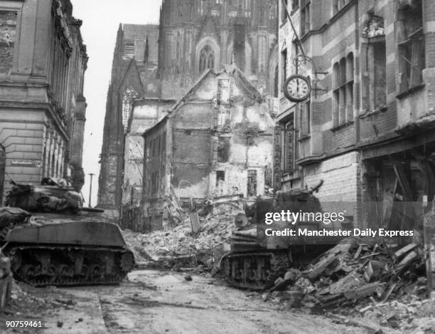 Scene of destruction in the German city of Cologne. In the foreground are tanks, probably American, and in the background is the cathedral which...