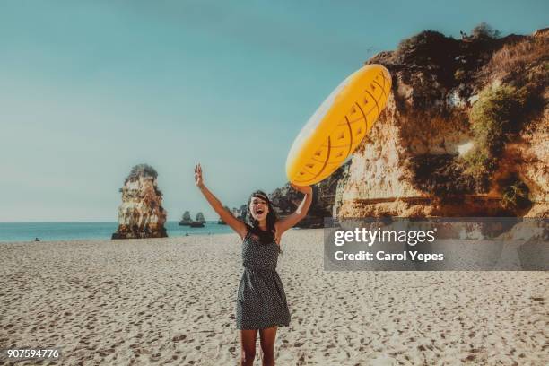 playing with inflatable ring at beach - distrito de faro portugal fotografías e imágenes de stock