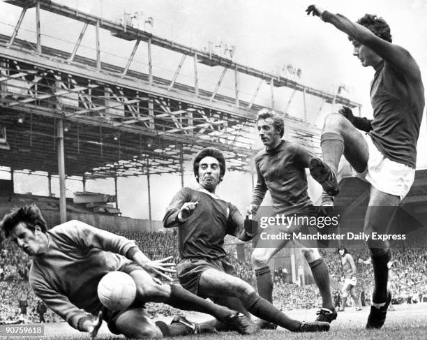 Manchester United's Denis Law looks on as team mate Brian Kidd almost scores, Liverpool's Roy Evans attempts to block.