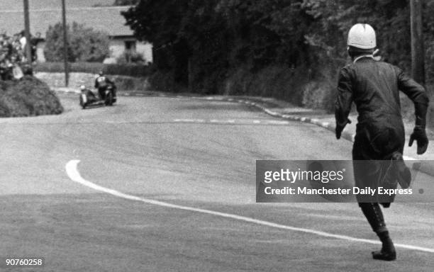 Sidecar passenger Don Simpson of Sheffield runs along after his driver, Bollington, the rider of bike No 28, hit the kerb. The world-famous TT...
