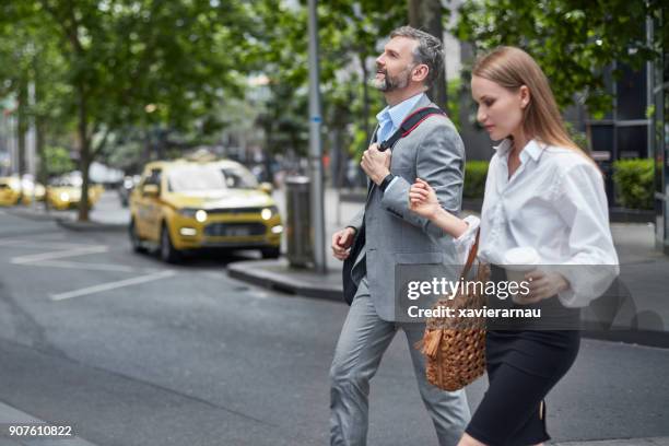 business colleagues crossing road in city - australia taxi stock pictures, royalty-free photos & images