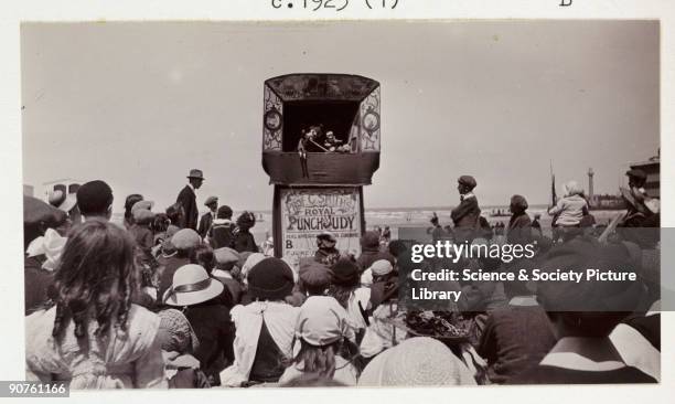 Snapshot photograph of a crowd watching a Punch and Judy show on the beach at Margate, Kent, taken by an unknown photographer using a No 2A Brownie...