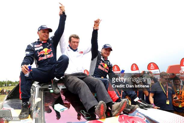Carlos Sainz of Spain and Peugeot Total celebrates victory with co-driver Lucas Cruz of Spain and Peugeot Team Manager, Bruno Famin at the end of...