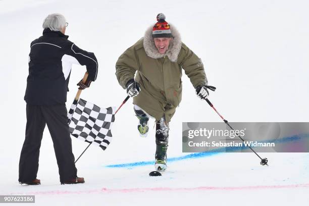 Gregor Bloeb reaches the finish line on one ski as Bernie Ecclestone waves the checkered flag during the KitzCharityTrophy on January 20, 2018 in...