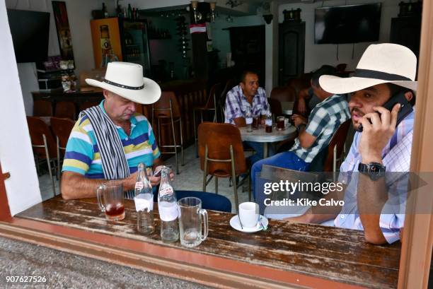 Colombians gather at the local cafes and bars around the main square in Filandia. The town of Filandia, currently known as 'La Colina Iluminada de...