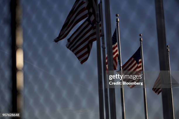 American flag fly near the Washington Monument in Washington, D.C., U.S., on Saturday, Jan. 20, 2018. The U.S. Government officially entered a...