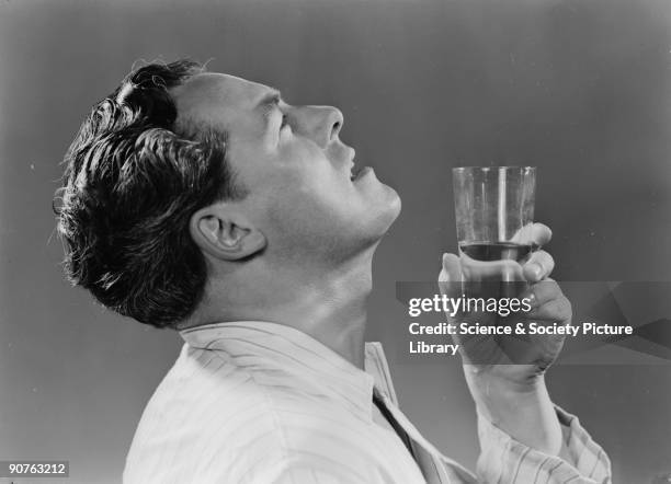 Photograph of a man gargling with a glass of water, taken by Photographic Advertising Limited in 1951. Photographic Advertising Limited, founded in...