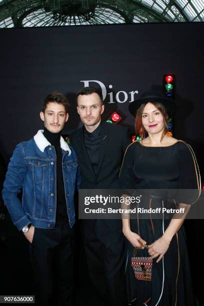 Stylist of Dior Men, Kris Van Assche standing between Pierre Niney and Natasha Andrews pose after the Dior Homme Menswear Fall/Winter 2018-2019 show...