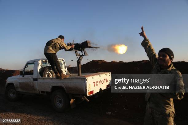 Turkish-backed fighters from the Free Syrian Army stand in the Tal Malid area, north of Aleppo, as they fire towards Kurdish People's Protection...