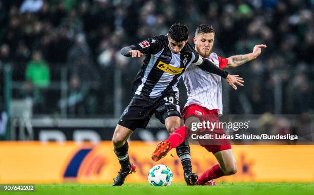 Lars Stindl of Moenchengladbach and Jeffrey Gouweleeuw of Augsburg fight for the ball during the Bundesliga match between Borussia Moenchengladbach...