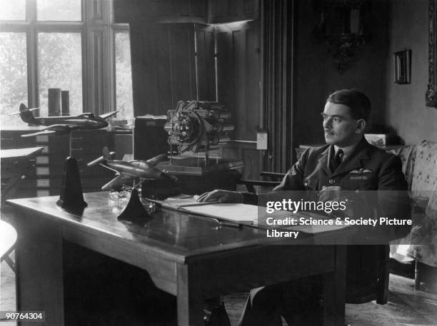 Frank Whittle photographed in his study at his war time headquarters at Brownsover Hall near Rugby, Warwickshire. The models shown are the...