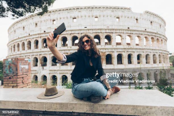joven tomando selfie frente coliseo - coliseo romano fotografías e imágenes de stock