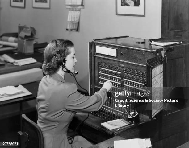 Photograph of a woman operating a telephone switchboard, taken by Photographic Advertising Limited in 1954. Photographic Advertising Limited, founded...