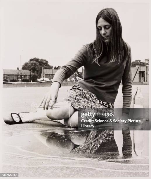 Photograph of a King�s Lynn schoolgirl adding water to a puddle to check for evaporation levels as part of a school science experiment, taken by Tony...