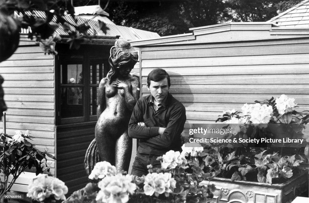 Man with statue at a flower show, c 1960s.
