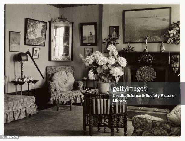 Snapshot photograph of a comfortable living room, taken by an unknown photographer in about 1930. Originally a shooting term, the word 'snapshot' was...