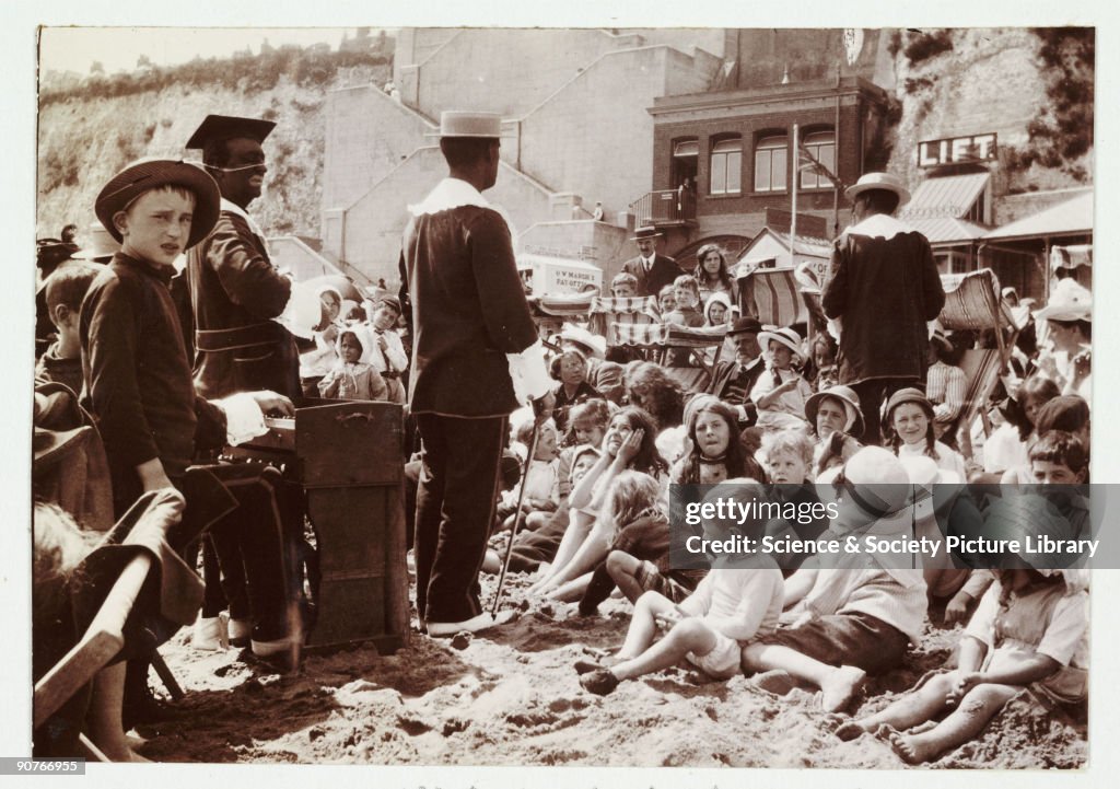 Crowd watching entertainers on a beach, Kent, c 1910.